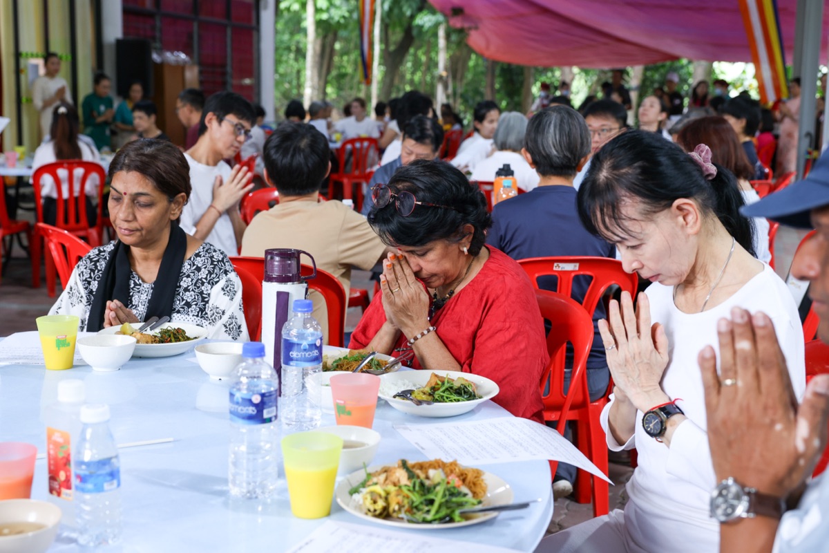 Participants offering a prayer of gratitude before the vegetarian meal