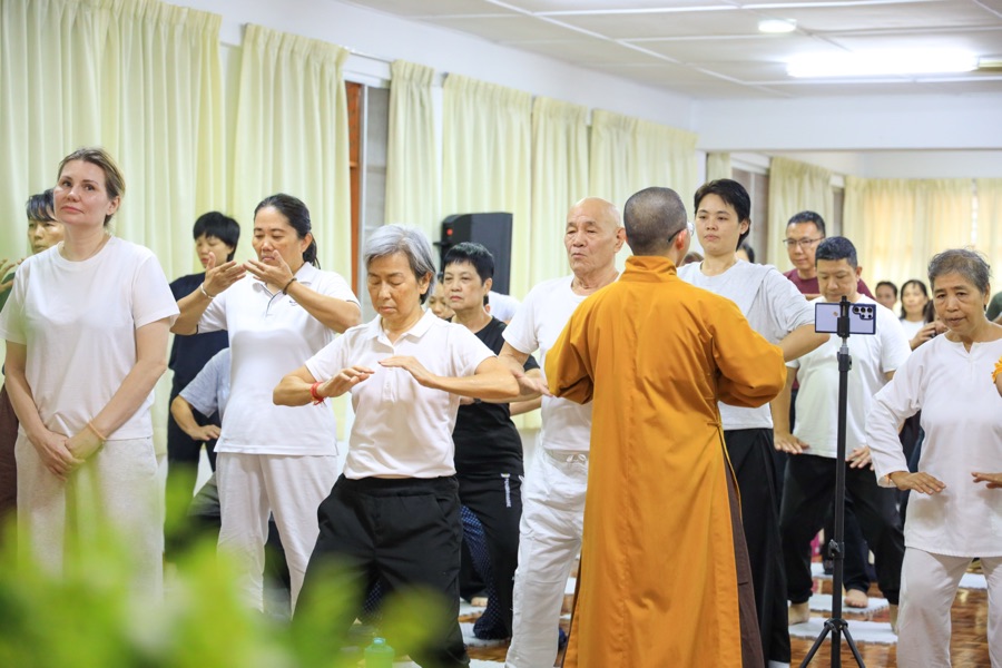 A monk leading participants through Qi Gong movements