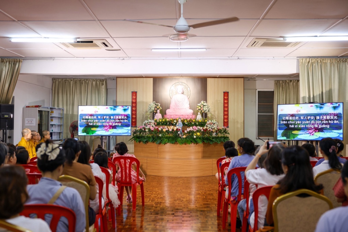 A full hall of participants during the chanting session